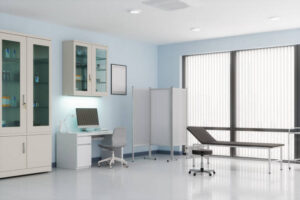 Doctor’s office with desk, cabinets and examination table.